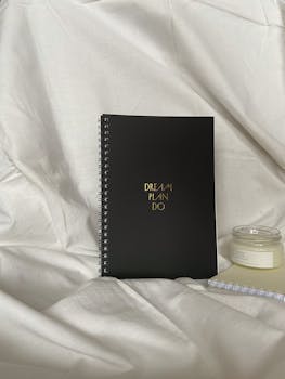 Black Notebook on White Textile