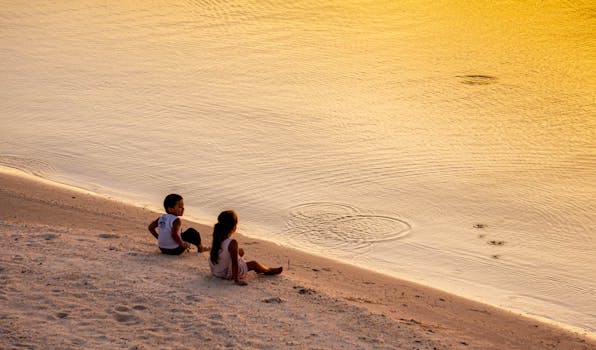 Children Sitting on Brown Sand